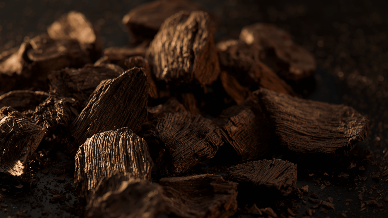 A close-up pile of raw agarwood (oud) chips